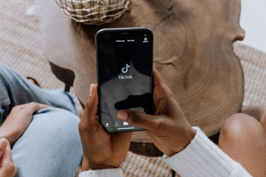 Elinde telefonla TikTok'ta gezen kullanıcı, sosyal medya reklam stratejilerini keşfediyor.