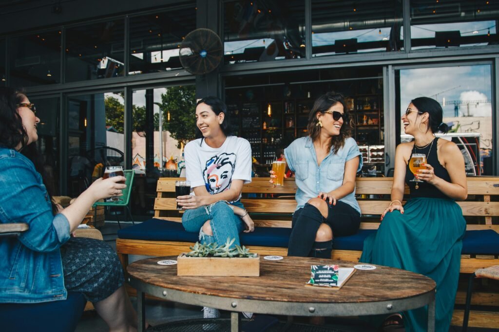 Restoran terasında bira içen ve sohbet eden arkadaş grubu