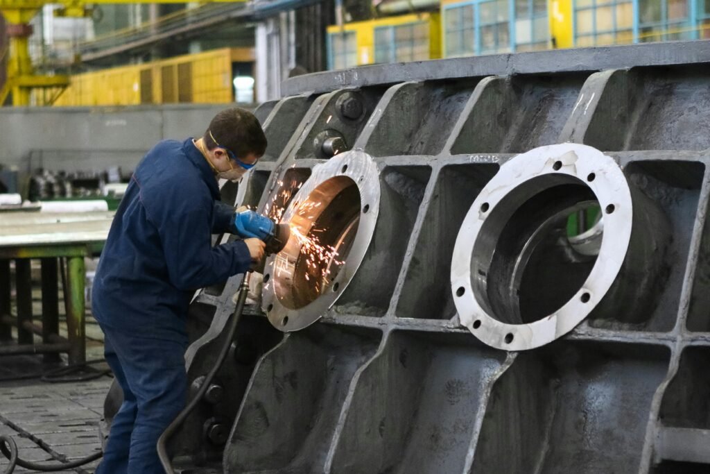 Sanayi sektöründe e-posta pazarlaması için büyük bir metal parçayı kaynakla işleyen fabrika işçisi. Ağır sanayi üretimi.