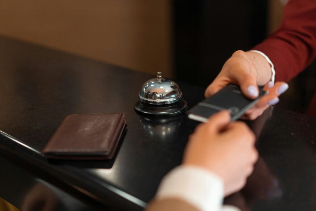 Otel resepsiyonunda check-in işlemi yapan müşteri ve görevli – otel dijital pazarlama