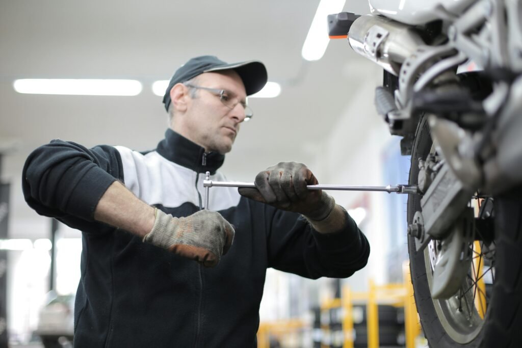 Bir tamircinin motosiklet üzerinde yedek parça montajı yapması – yedek parça e-ticaret pazarlaması ⚙️