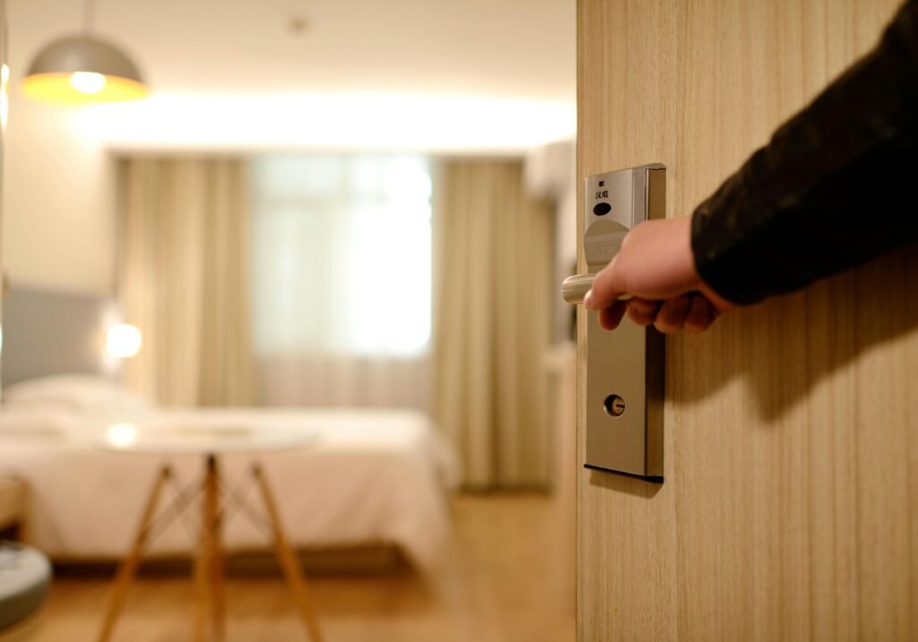 Otel odasının kapısı açılırken modern iç tasarımlı oda görünüyor – otel web sitesi optimizasyonu