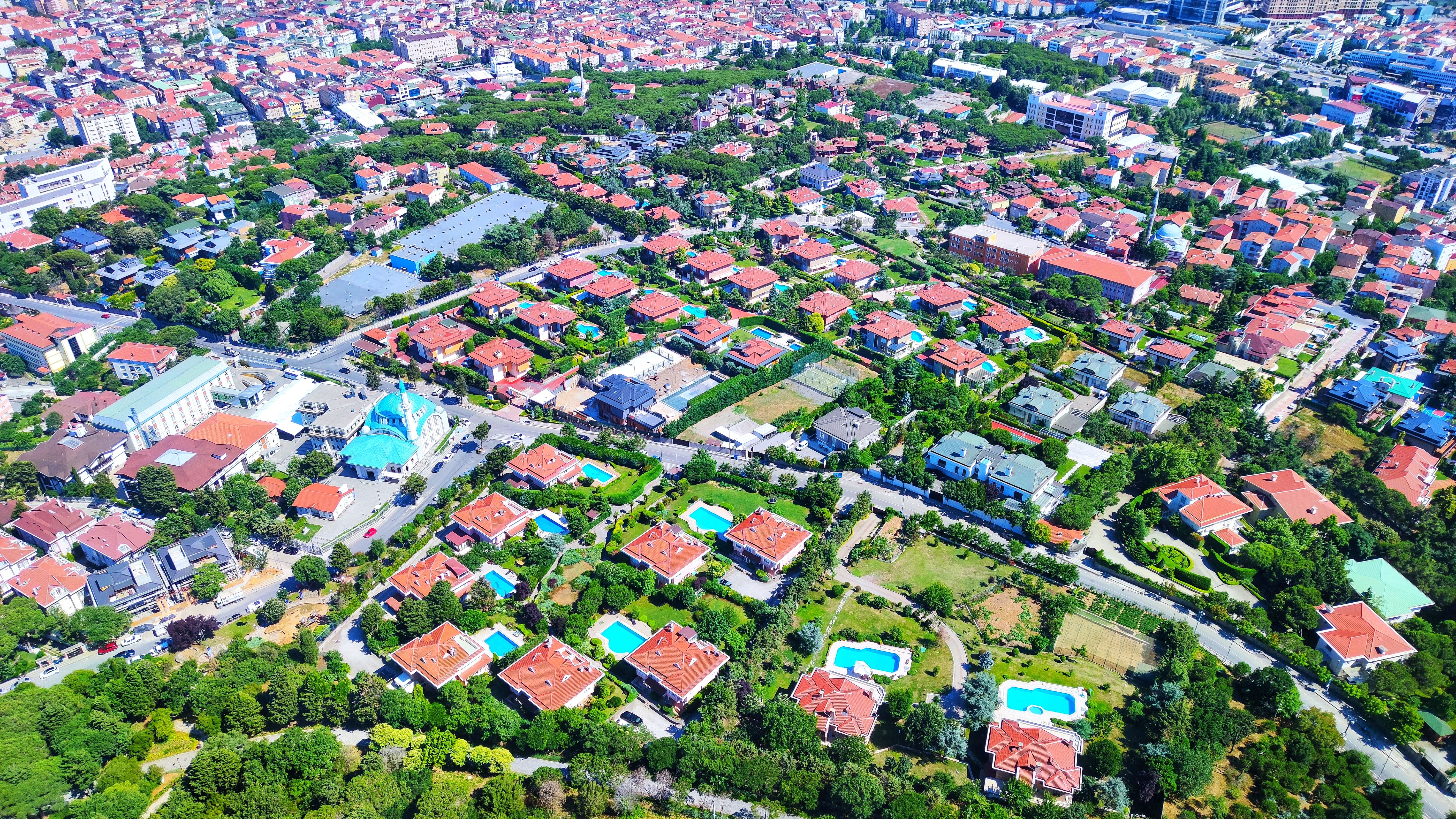 Geniş açıdan çekilmiş havuzlu lüks konut projeleri ve modern şehir planlaması üzerinde gayrimenkul dijital pazarlama stratejileriyle doğru hedef kitleye ulaşmayı ve emlak satışlarını artırmayı simgeleyen kuş bakışı görünüm.